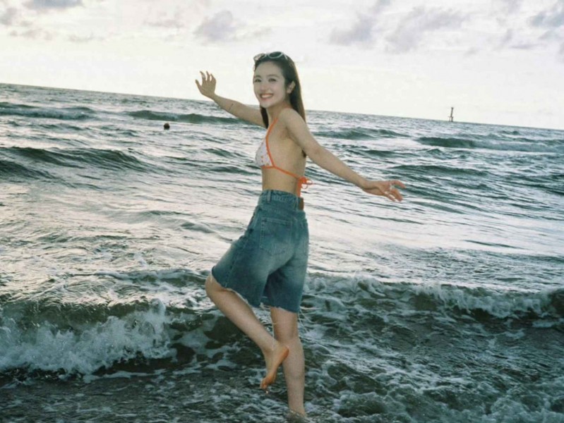 沙滩明星穿搭指南：李兰迪比基尼配牛仔短裤，赤脚嬉戏海边笑容满分